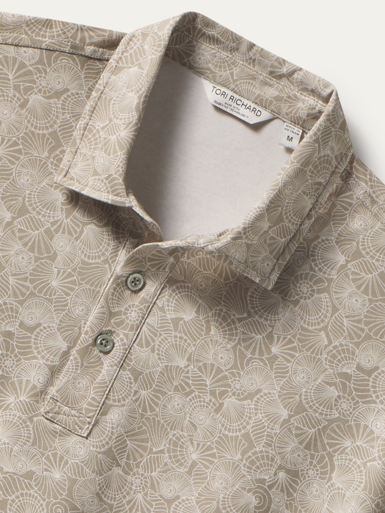 Beige geometric seashell-print Pima cotton polo shirt, front view with visible tag shown in both images.