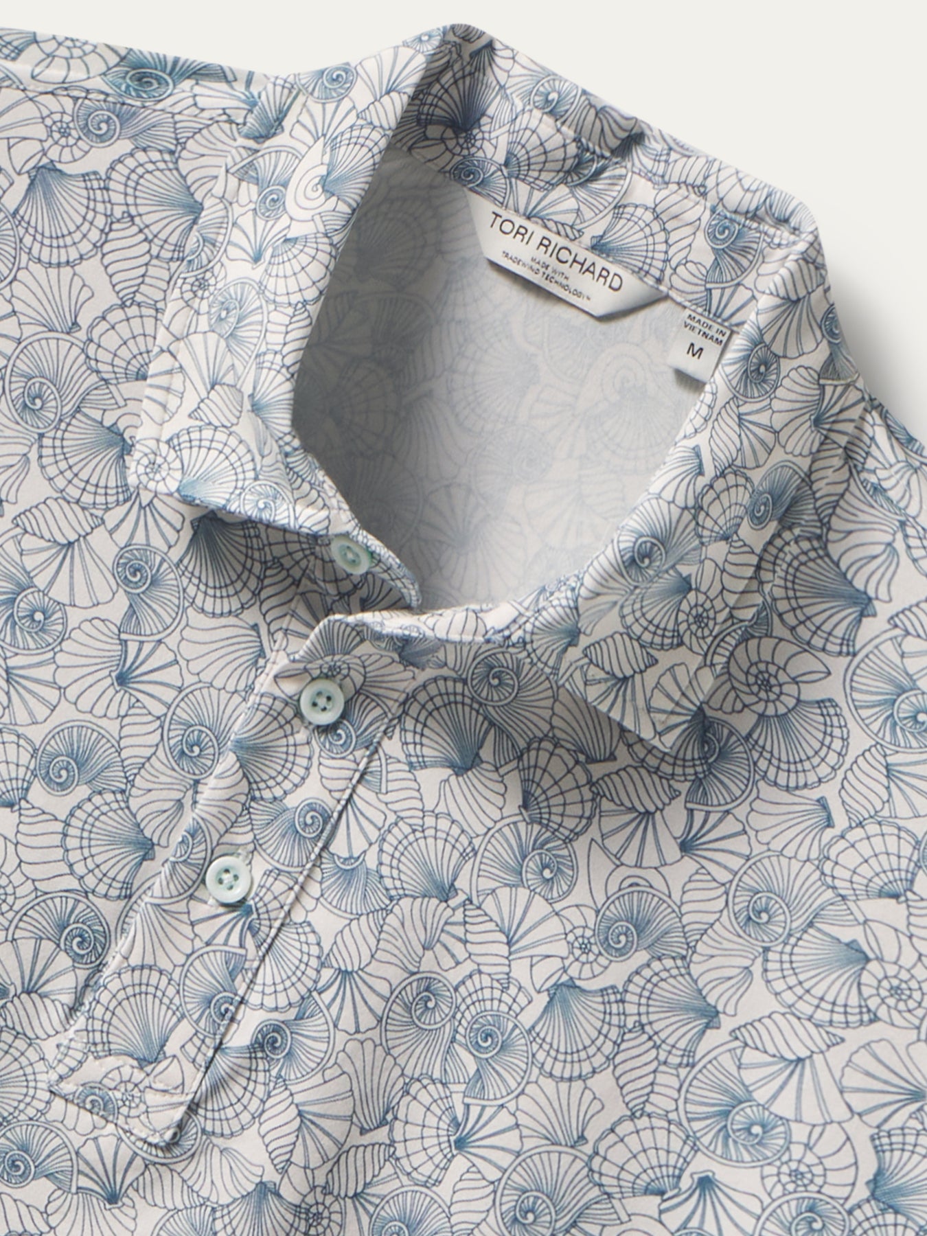 Blue and white seashell-print polo shirt with three buttons, front view shown in both images.