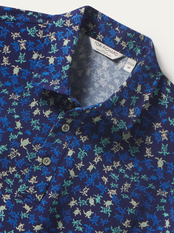 Blue honu hatchlings print polo shirt with three buttons, front view shown in both images.