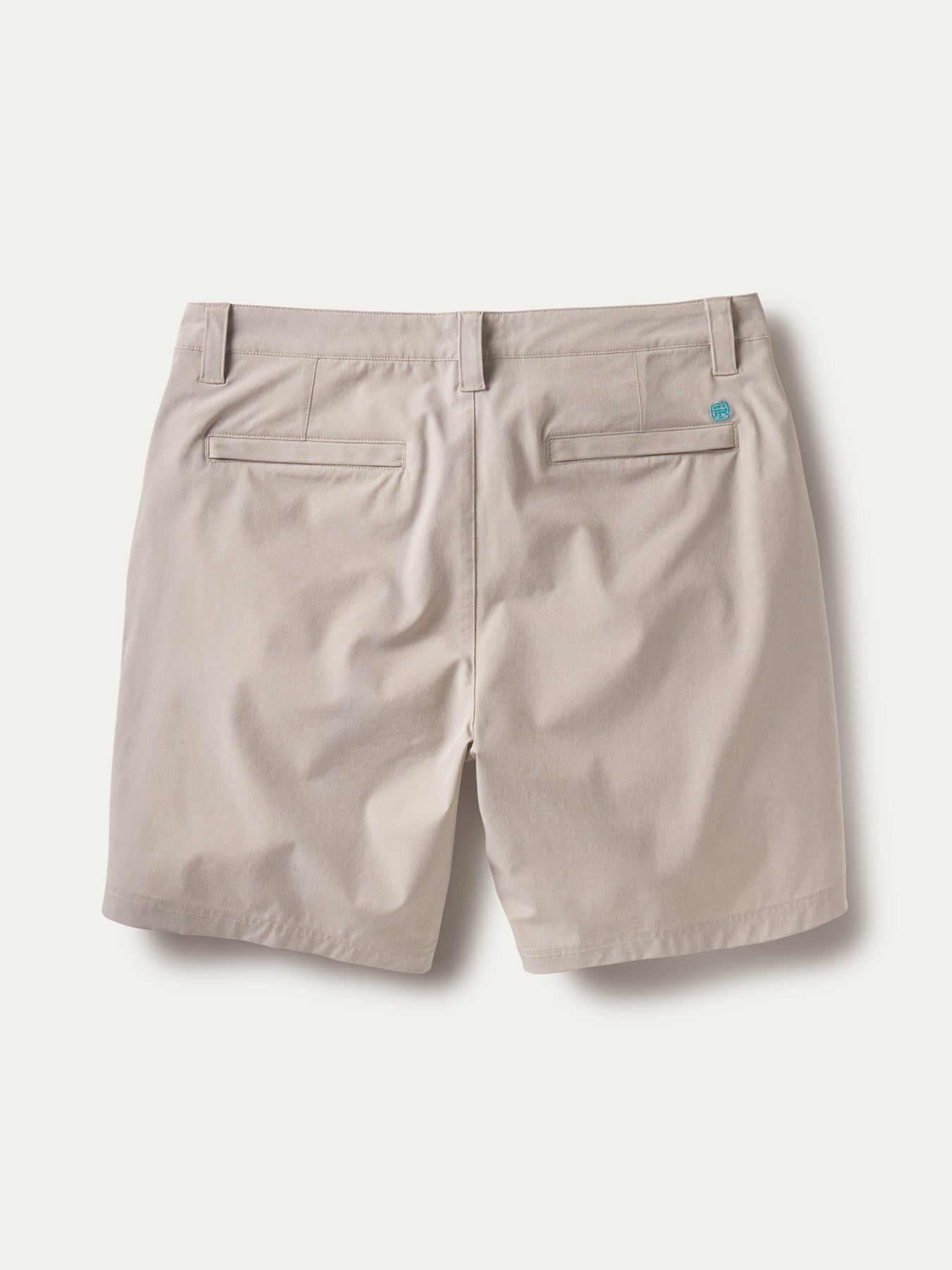 Beige performance shorts, back view; belt loops, welt pockets, stretchy fabric.