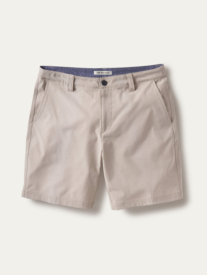 Beige khaki solid performance shorts, front view showing pockets, button closure, and stretch fabric{{/AltText}}.