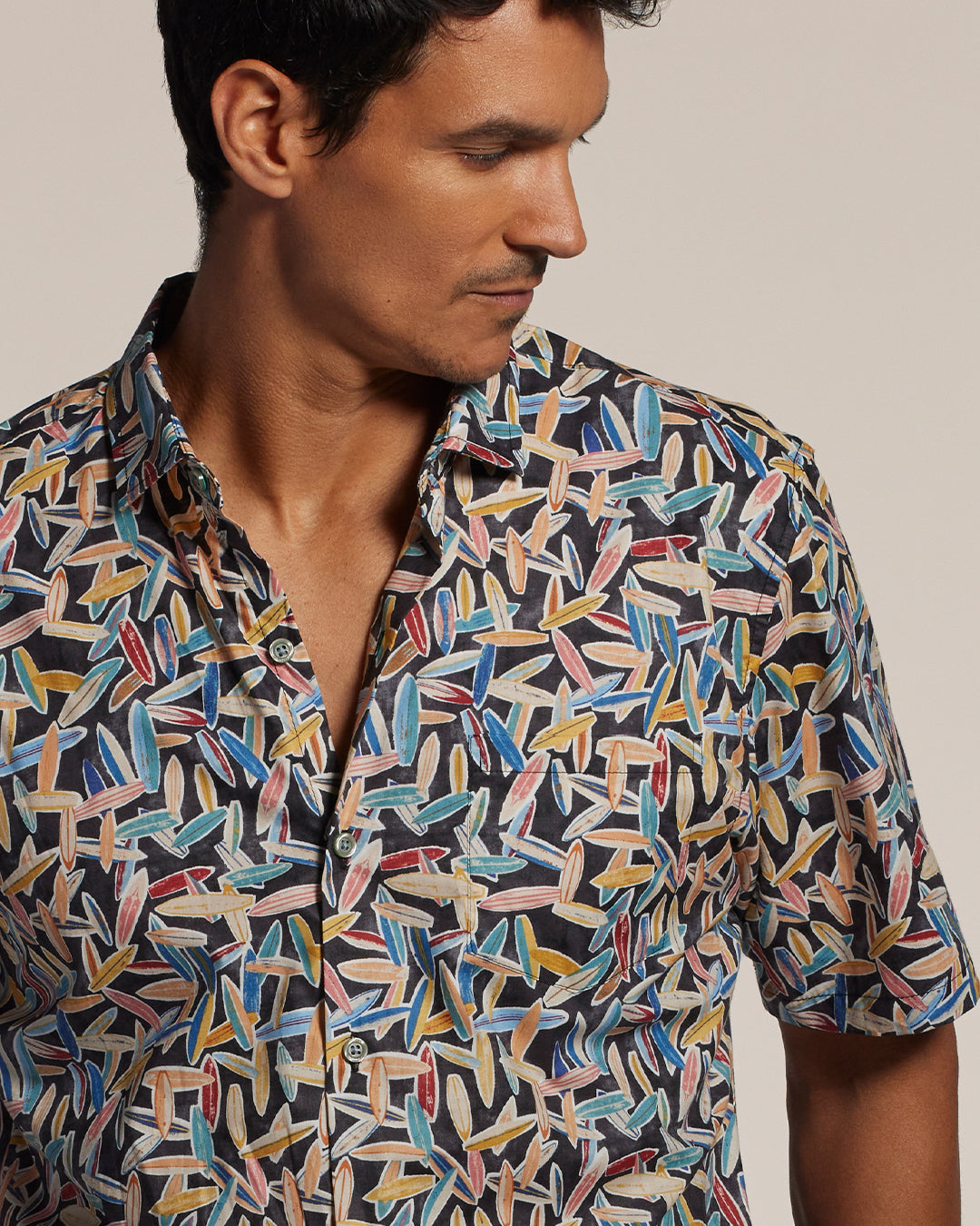 Red, yellow, and blue surfboard-print short-sleeve shirt, front view on a model.