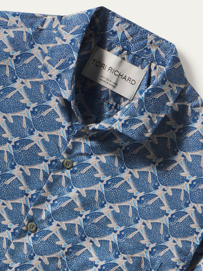 Close-up of a blue and white patterned button-down shirt by Tori Richard, showing the collar label and part of the fabric print.