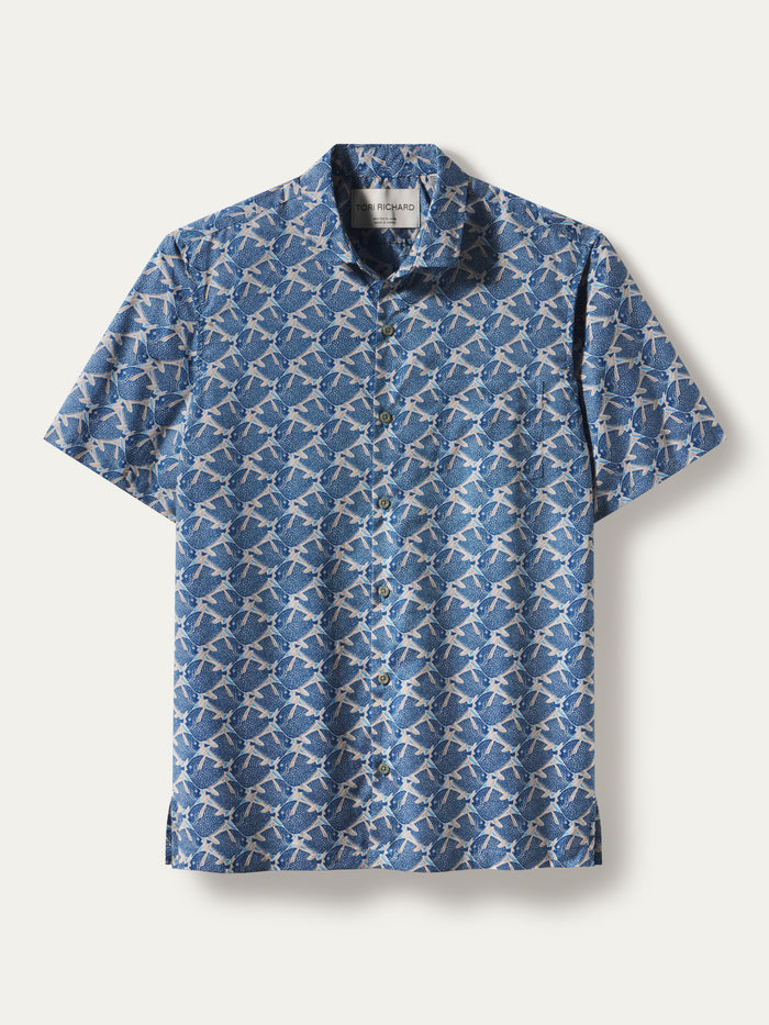 A short-sleeve button-up shirt with a blue and white repeating geometric pattern, displayed flat against a light beige background.