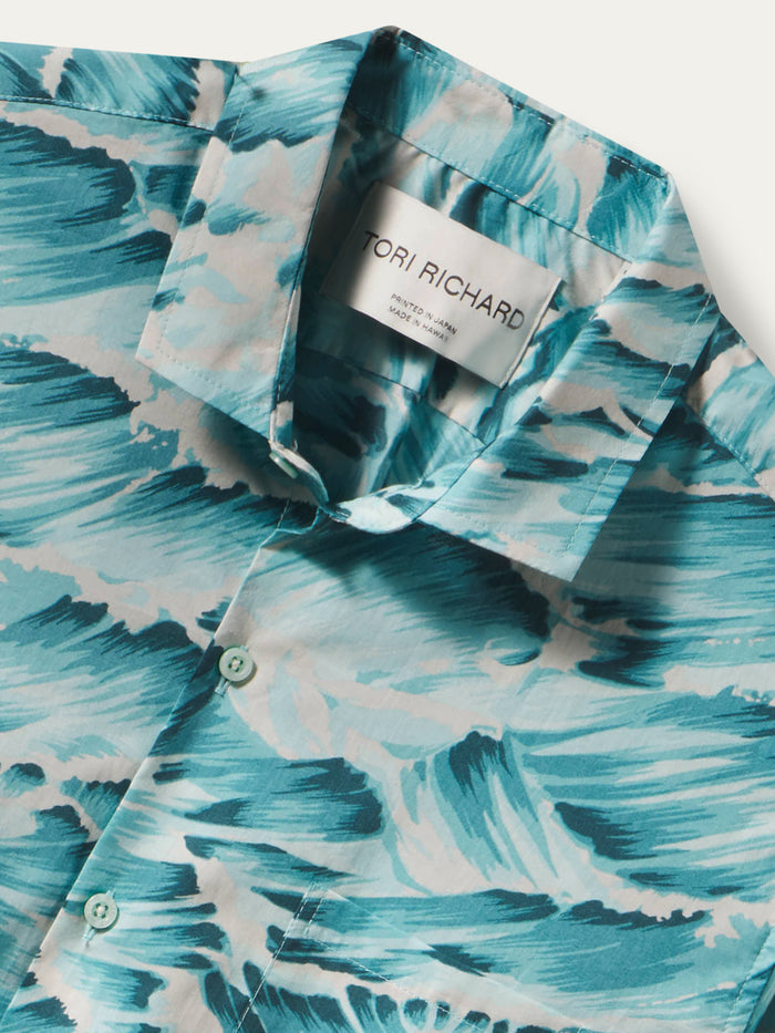 A close-up of a Tori Richard button-down shirt featuring a blue and white wave pattern, with the brand label visible inside the collar.