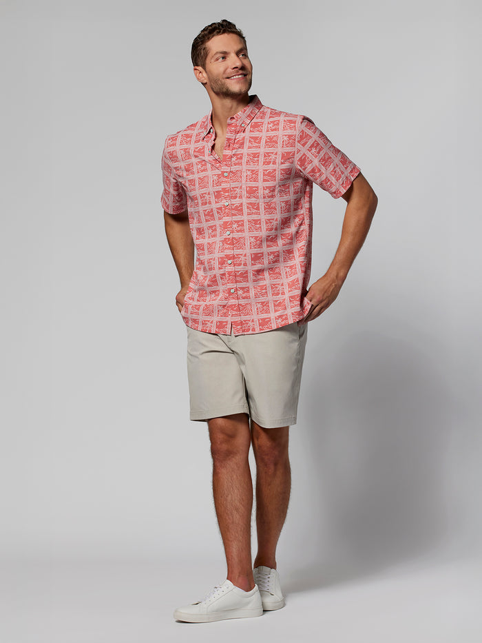 Red geometric-pattern short-sleeve shirt, beige shorts, and white sneakers, front view.