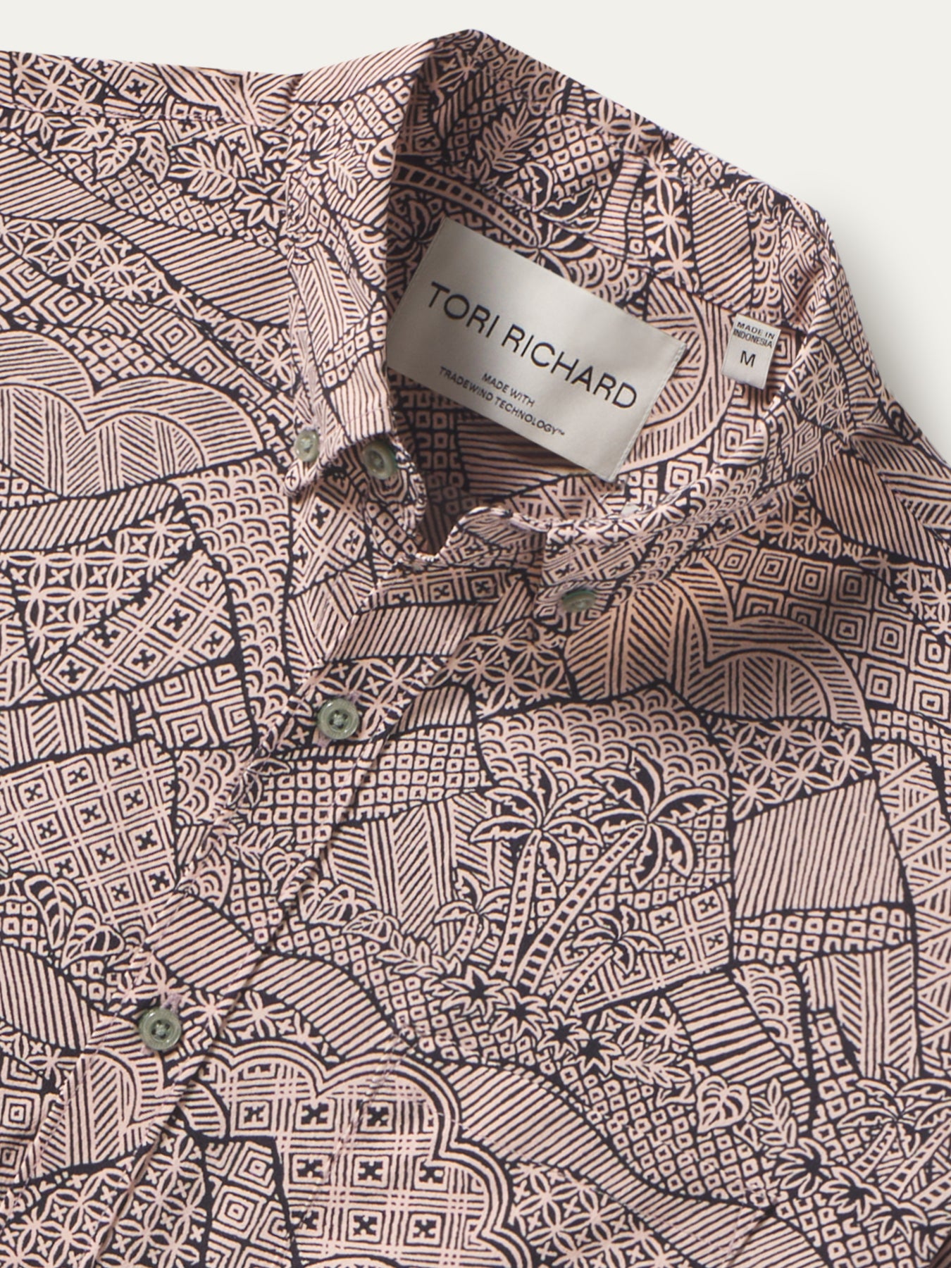 Front and back views of a brown and black geometric and floral-print short-sleeve shirt.