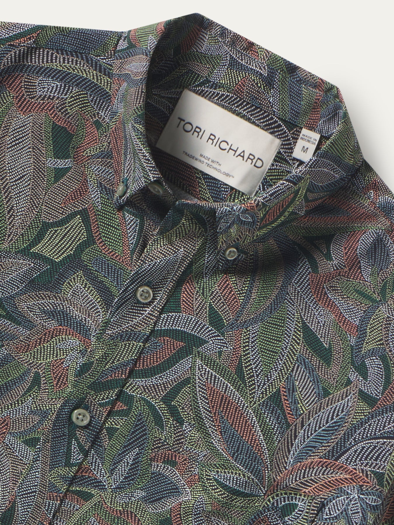 Multicolored leaf-print, moisture-wicking button-up shirt, front view shown in both images.