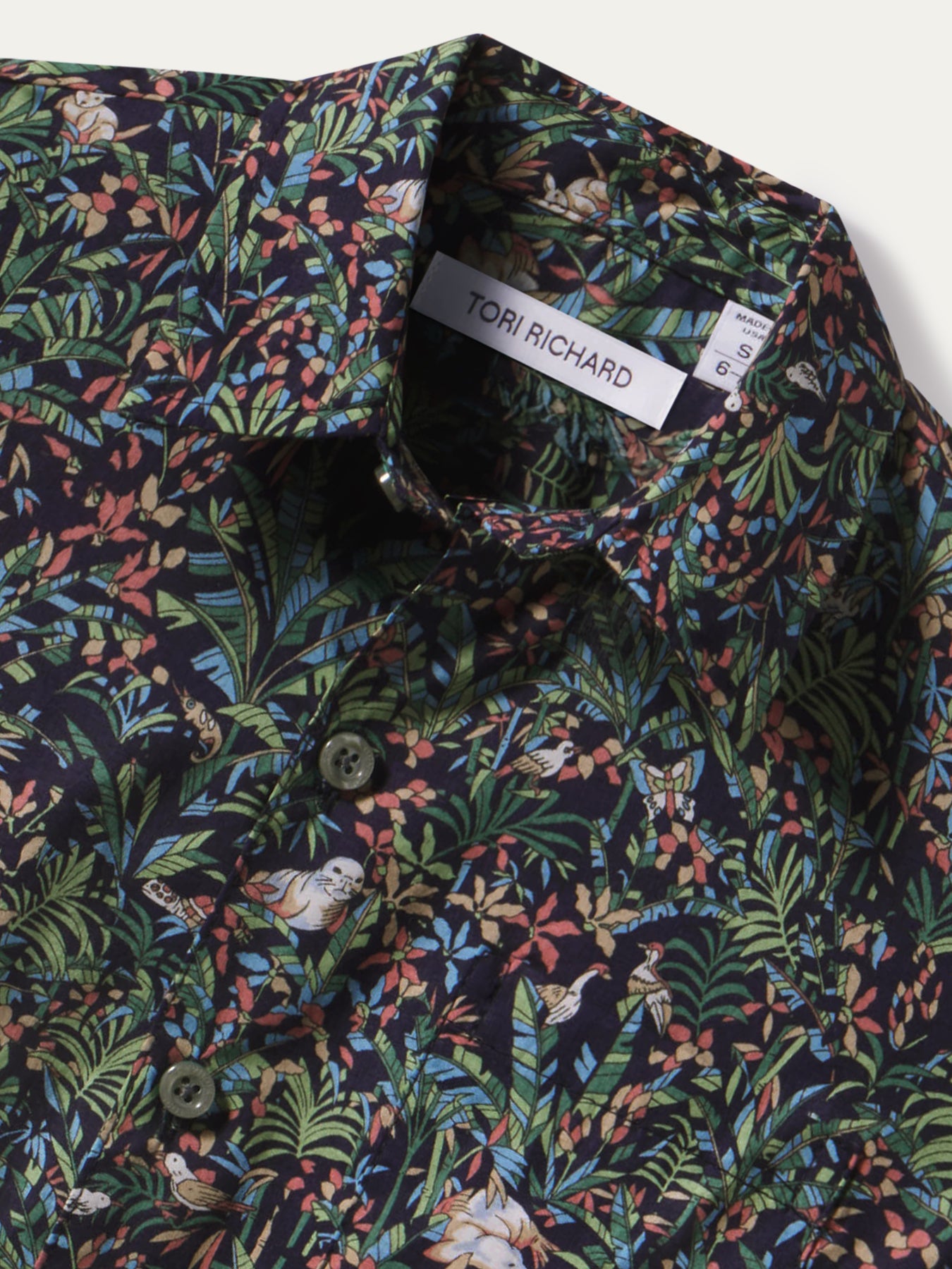 Blue and green floral-leaf print cotton short-sleeve shirt, collar label detail view.