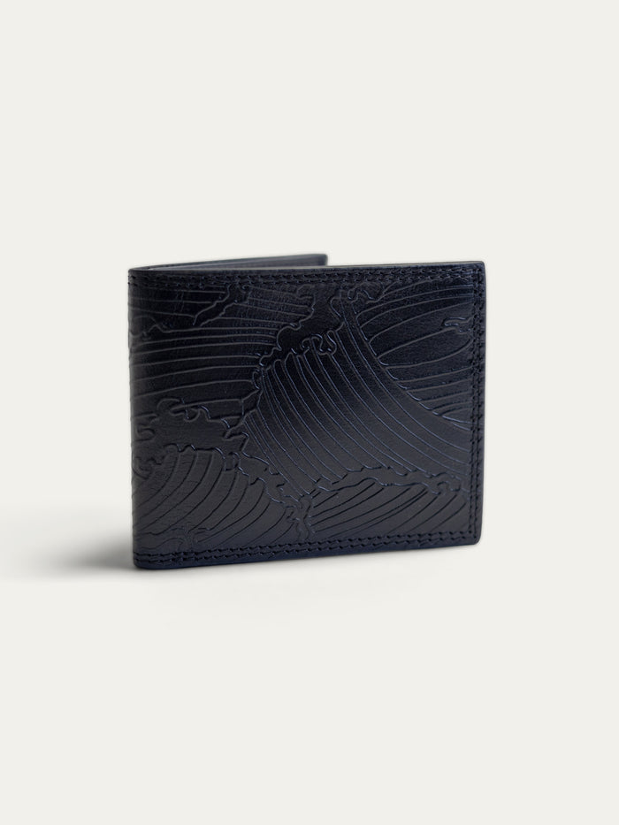 A dark navy blue leather bifold wallet with an embossed wave pattern, shown on a light off-white background.