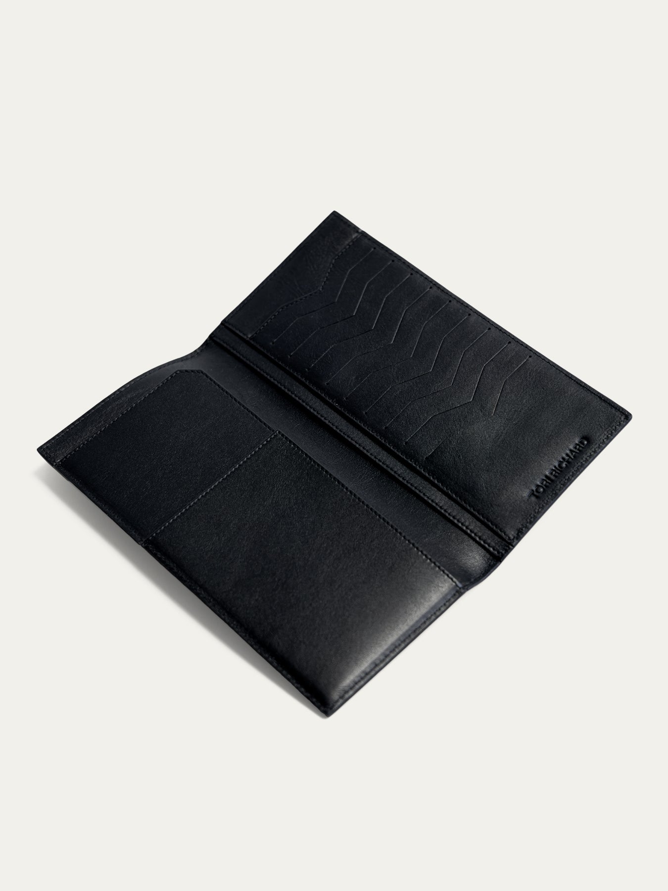 Black leather travel wallet with card slots and pocket, shown open on light background in two images.