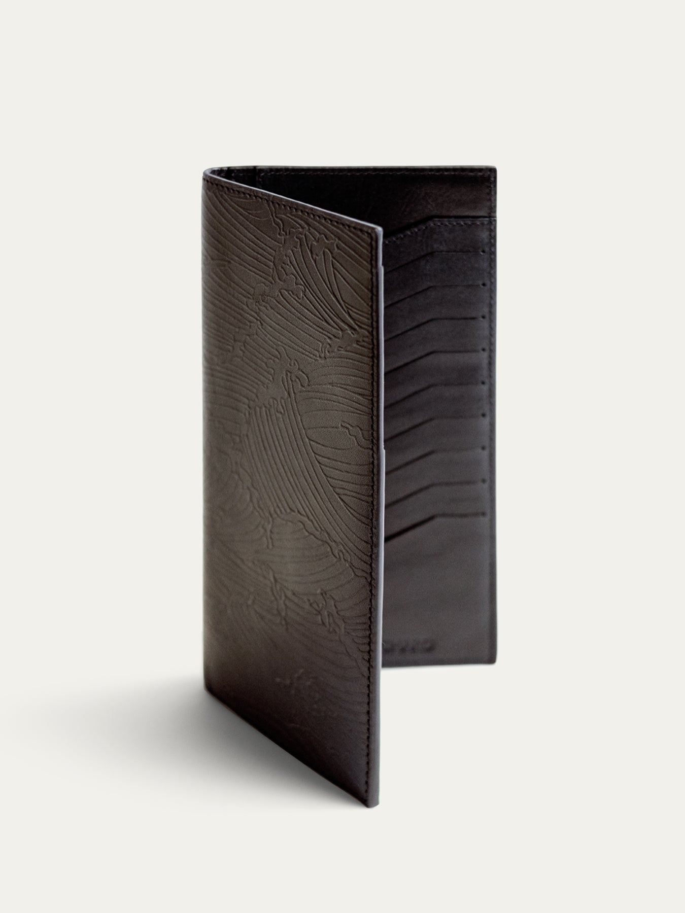 Black textured leather travel wallet, open and upright, with passport holder detail shown.