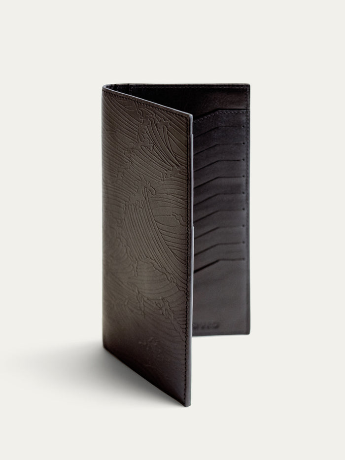 Black textured leather travel wallet, open and upright, with passport holder detail shown.