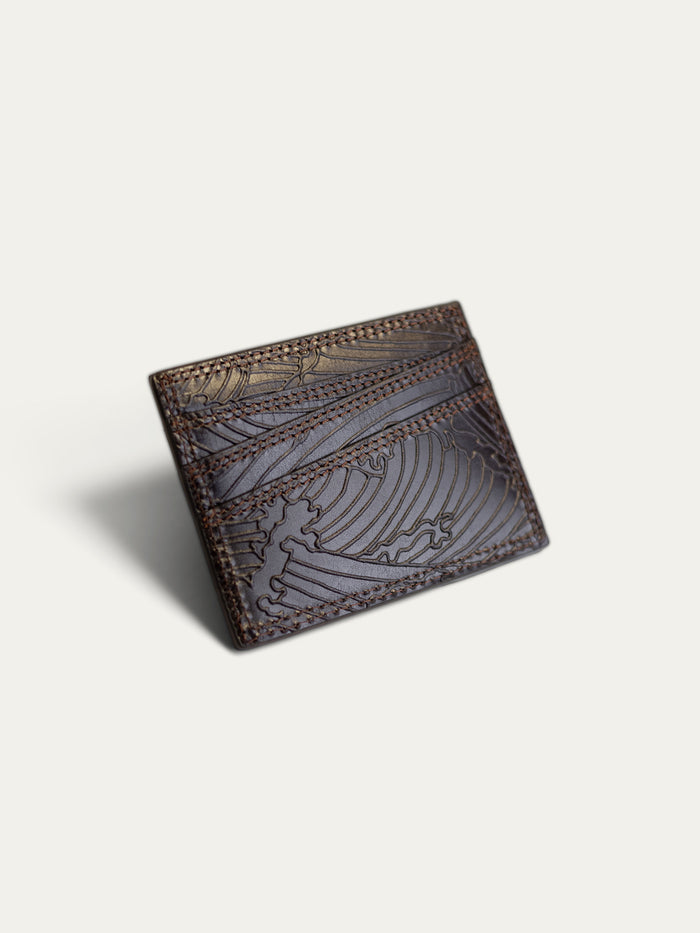 A dark brown leather card holder wallet with embossed wave patterns and contrast stitching, shown on a light off-white background.