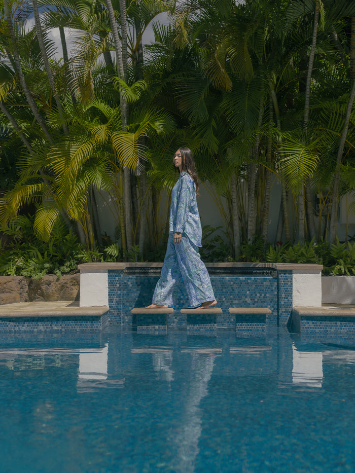 Blue dress with multicolor floral wide-leg pants, side view by pool with greenery (Images 1 & 2).