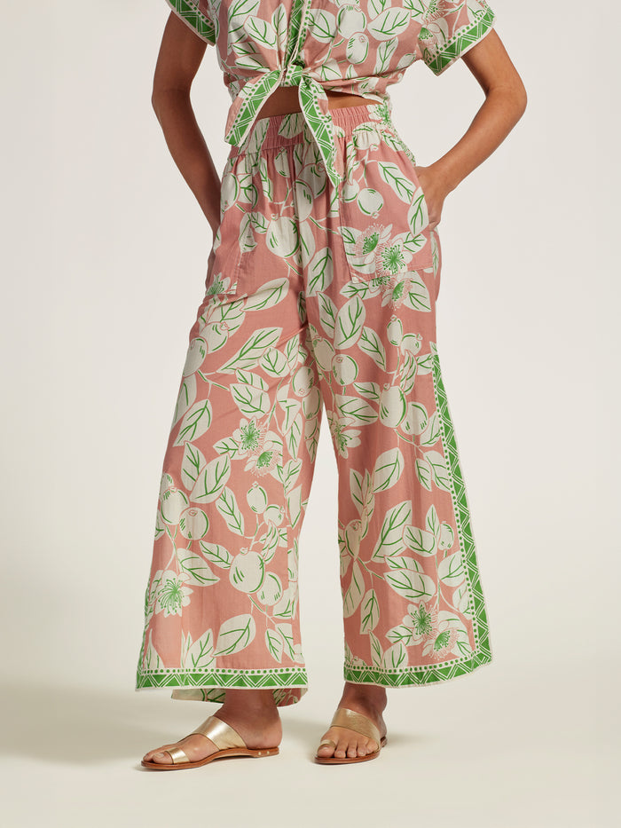 Pink floral cotton voile pants with green trim, front view.