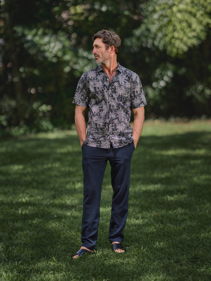 Navy blue Lanai Pant Tradewind Technology and grey patterned short-sleeve shirt, full-length view.{{/AltText}}.