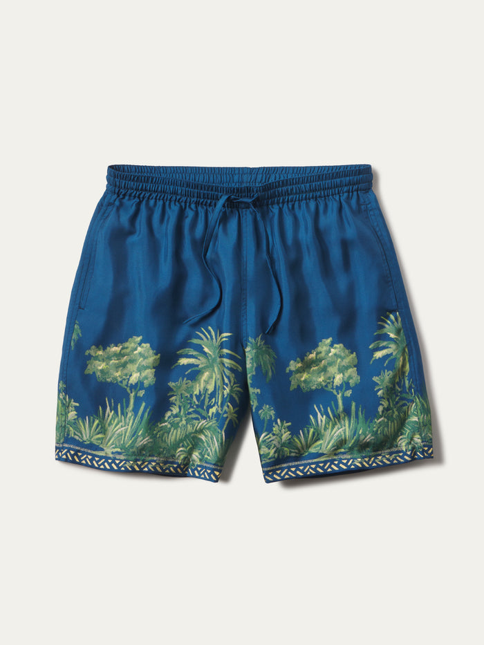 Blue patterned swim shorts with a tropical palm tree print and a decorative geometric border at the hem, shown flat on a light beige background.