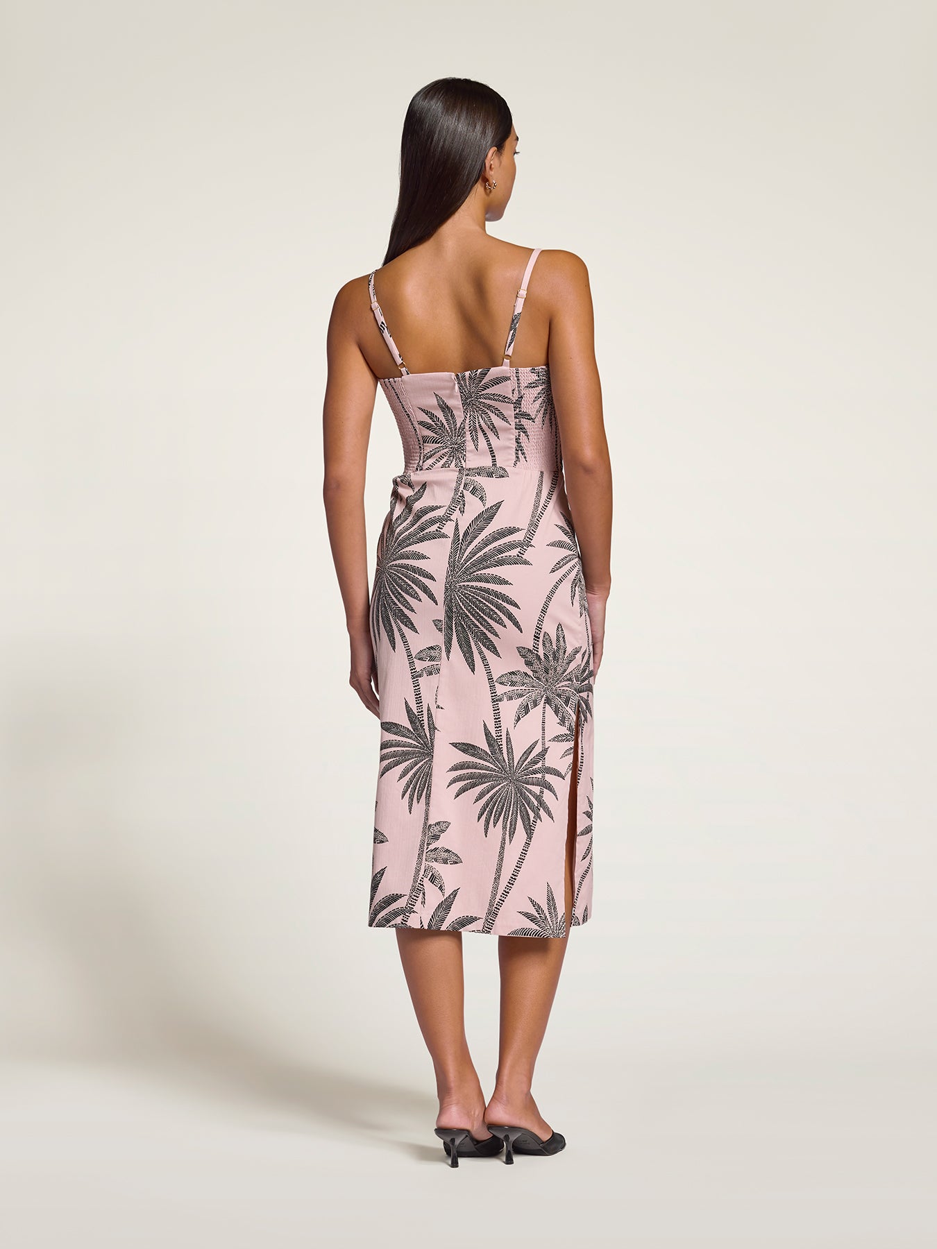 Blue floral-print midi dress, back view, styled with black heels.