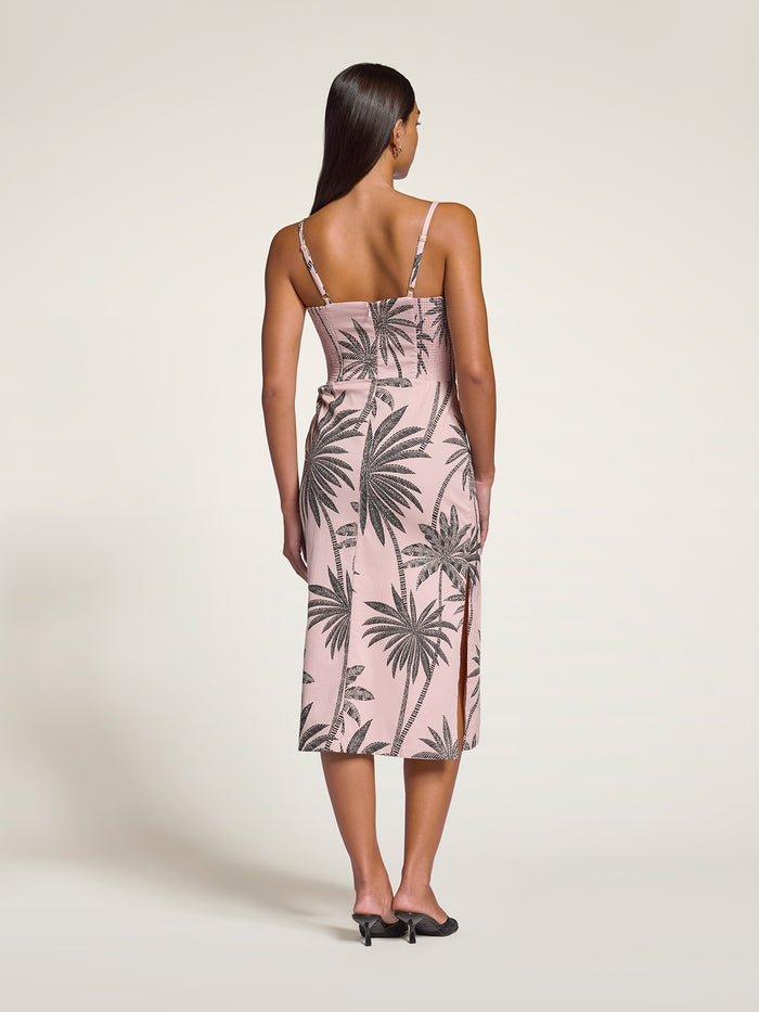 Blue floral-print midi dress, back view, styled with black heels.
