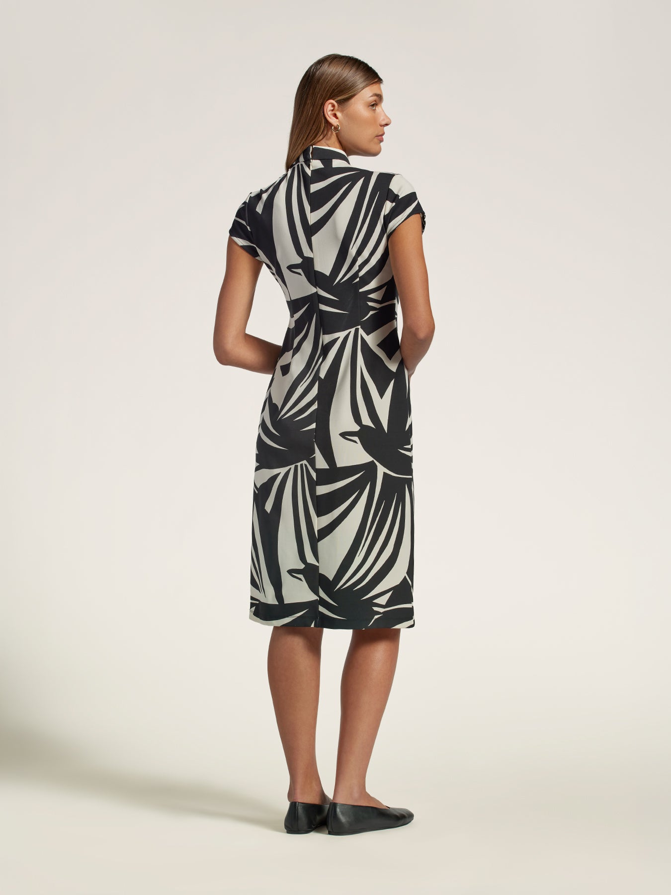Black and white patterned midi dress with mandarin collar, back view.