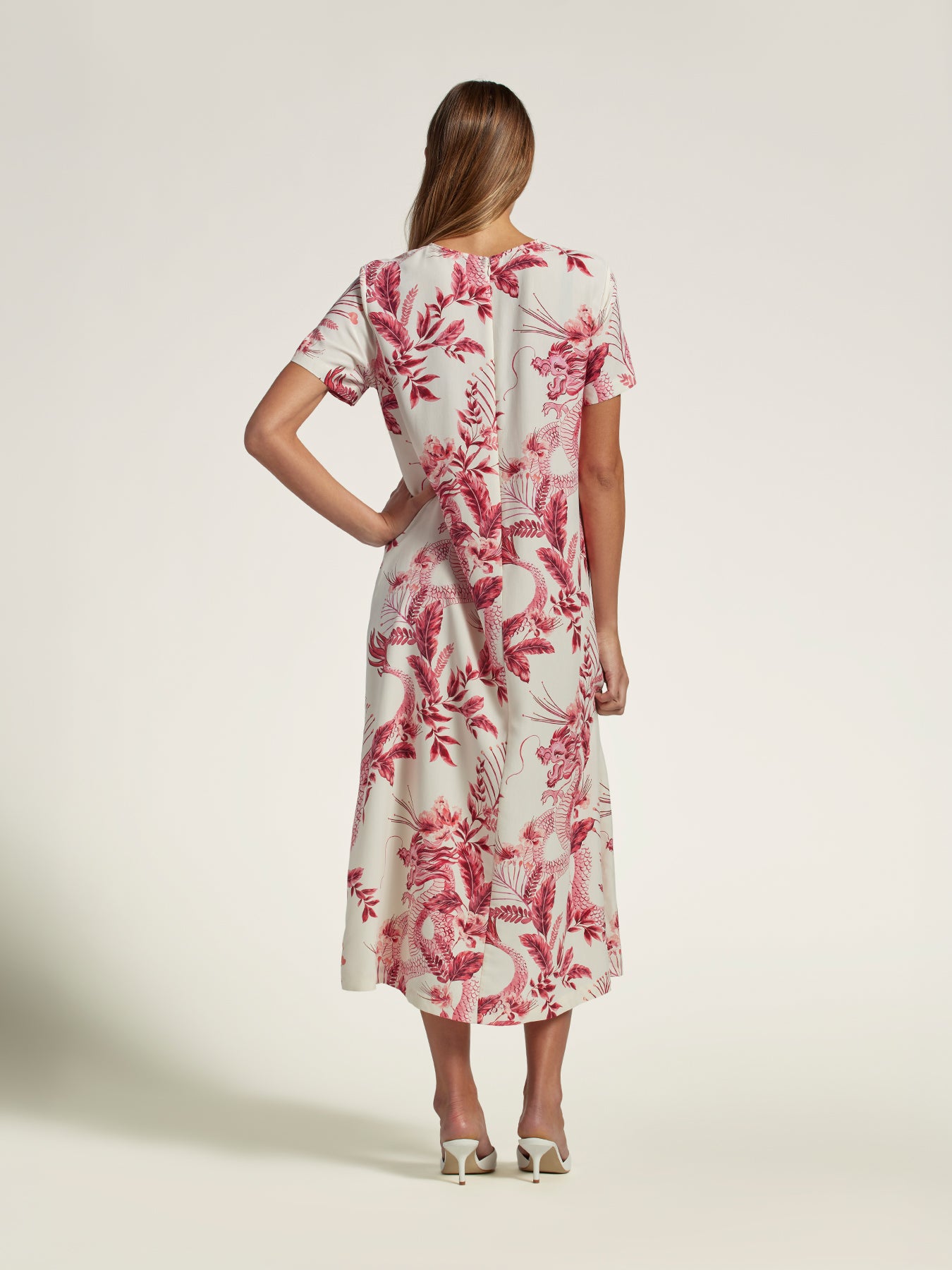 Deep green solid maxi dress, back view, white heel detail.