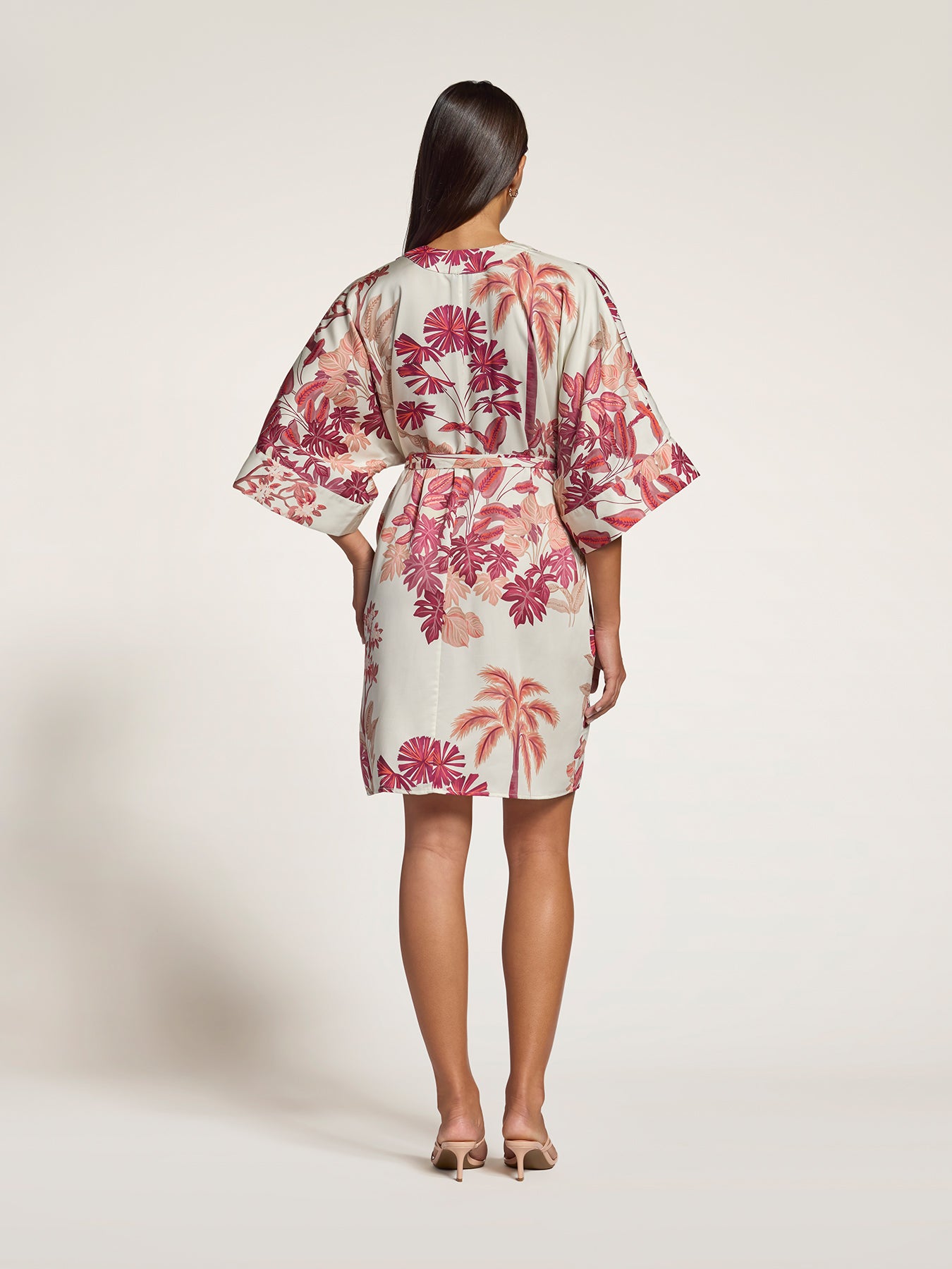Yellow tropical-print dress, back view with heels against a plain background .