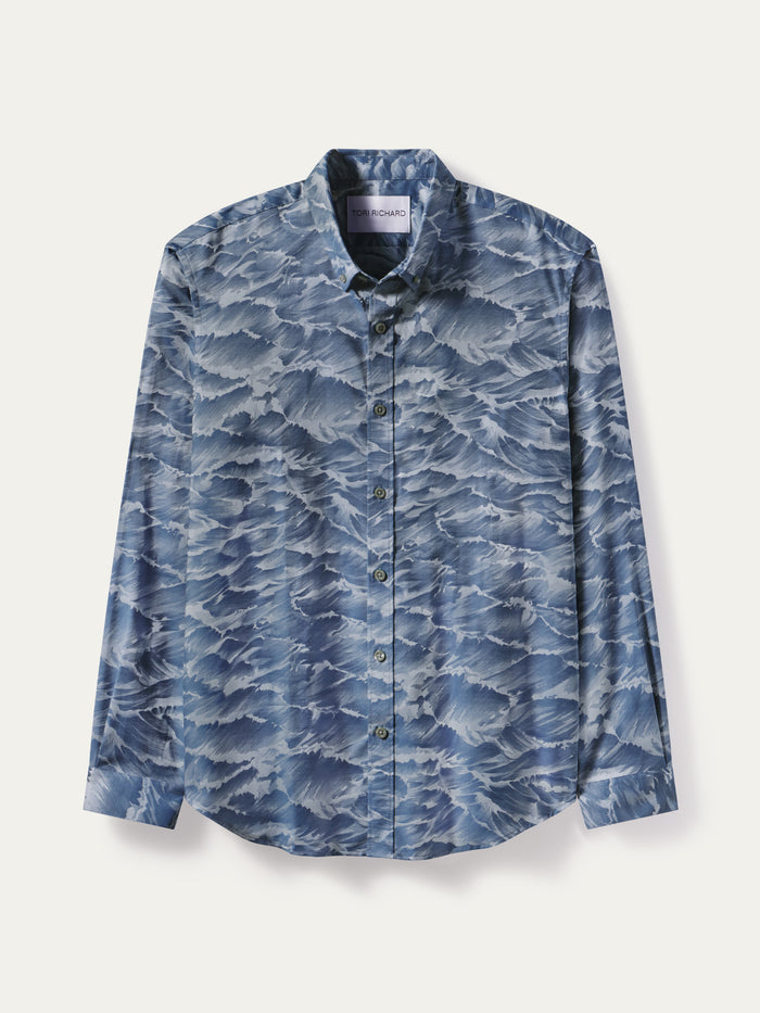 A long-sleeve button-up shirt with a blue and white wave pattern, displayed flat against a light off-white background.