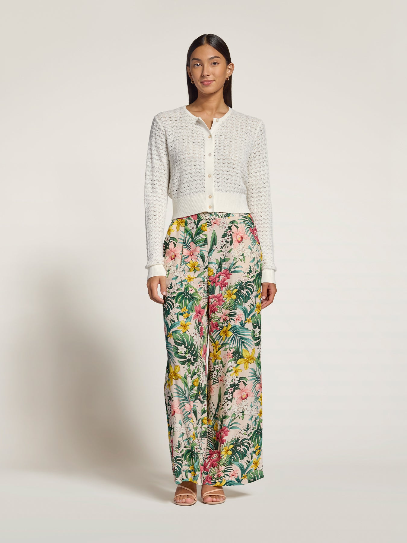 White lace pointelle cardigan with multicolor floral wide-leg pants, full front view shown in two images.