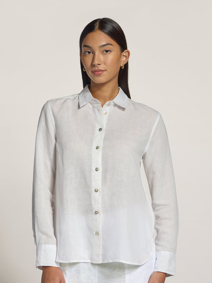 White solid linen top, front view worn by woman against light background.