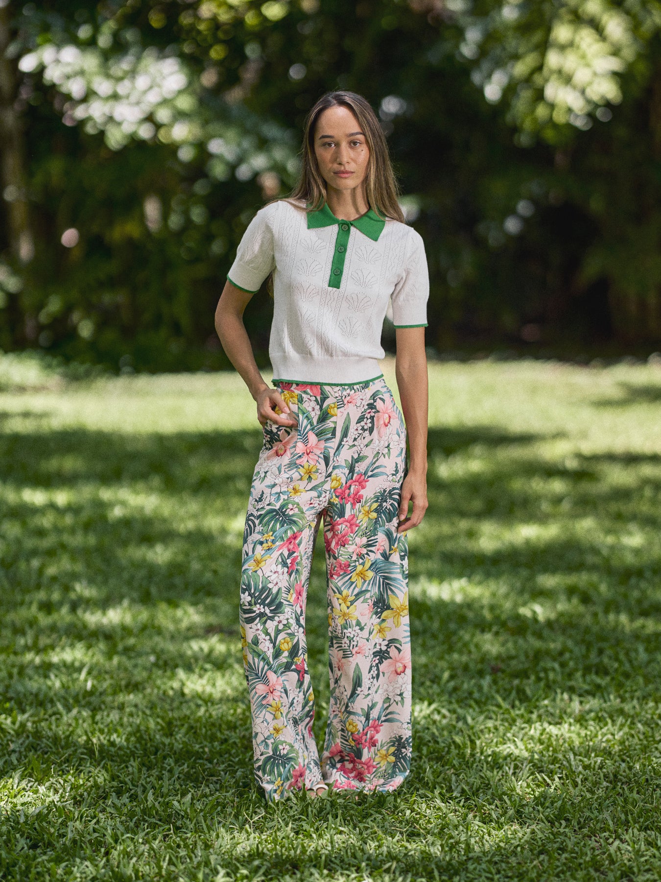White contrast-trim pointelle Mera polo and green floral wide-leg trousers, full-length view.{{/AltText}}.