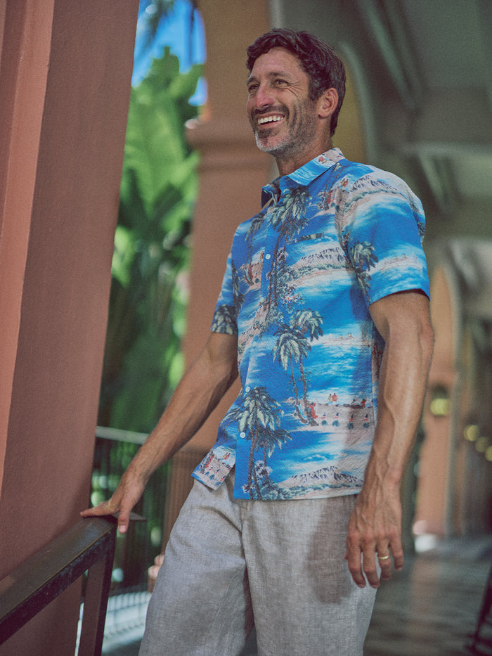 Blue palm tree-print Bon Voyage Tradewind Technology short-sleeve button-down shirt, side view.{{/AltText}}.
